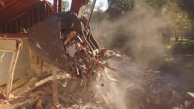 Close On Excavator Bucket Removing Debris From Demolished House
