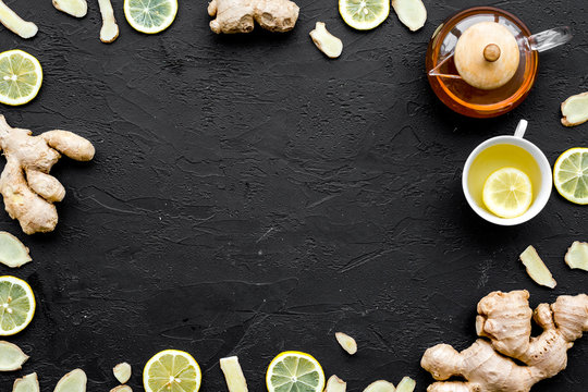 Tea for cure colds. Cup, teapot, ginger root and lemon on black background top view copy space © 9dreamstudio