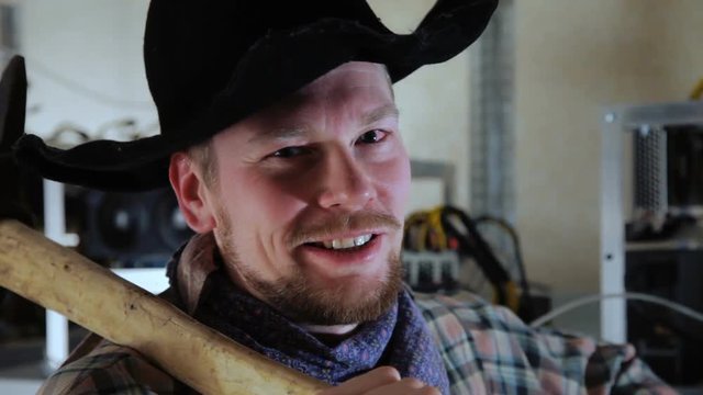 Cheerful man in miner suit with pickaxe in room with farms.