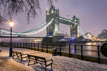 Naklejka premium Londyn zimą: Tower Bridge wieczorem ze śniegiem i lodem