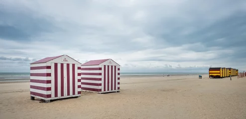 Gardinen Row of colorful beach huts on a cloudy day © Erik_AJV
