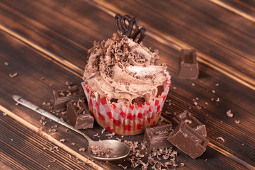 Delicious chocolate cake, with chocolate cream, on dark wood background.