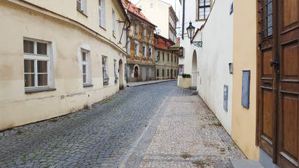 Fototapeta na wymiar View on the narrow cobblestoned street in Prague, Czech Republic.