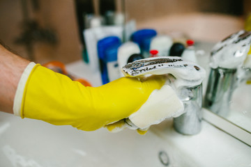 Man in gloves wash faucet sponge