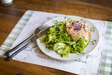 green sad with tuna on a vintage plate with handmade knife and fork.