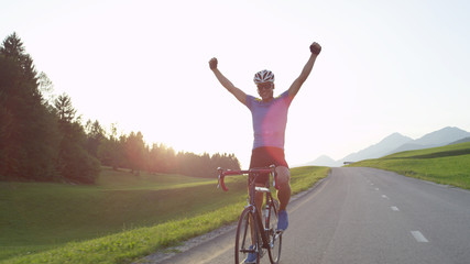 LENS FLARE: Caucasian rider celebrates finishing bike tour through countryside