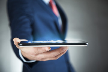 business man hand tablet on dark background