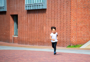 Fototapeta na wymiar Little child having fun by running on the streets