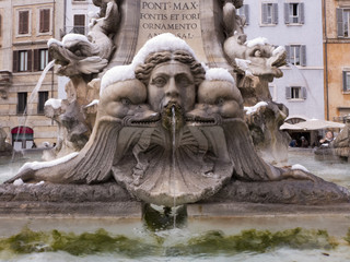 Ein Brunnen in Rom mit schnee auf den Köpfen der Skulpturen