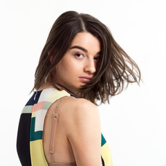 Portrait of a beautiful young woman wearing dress with geometric pattern wind blows her hair on...