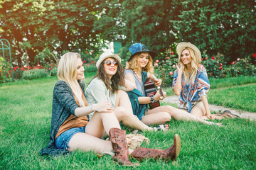 Fototapeta premium Summer holidays, vacation, travel and people concept - smiling young hippie women with guitar playing music. Funny time for the best friends. Lifestyle. Boho style.