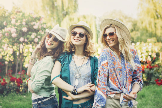 Happy friends in the park on a sunny day . Summer lifestyle portrait of three hipster women  enjoy nice day, wearing bright sunglasses. Best friends girls having fun, joy. Lifestyle