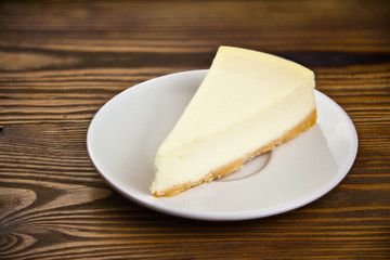 classic cheesecake on white plate on  wooden table