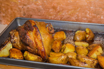 oven baked pork leg with potatoes .