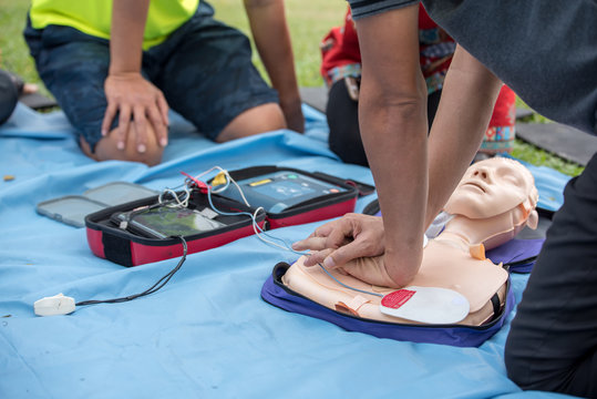 First Aid - CPR Training Chest Compression on Training Manikin with Automated External Defibrillator (AED) Box