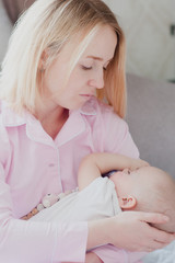 mother gently holding a newborn baby