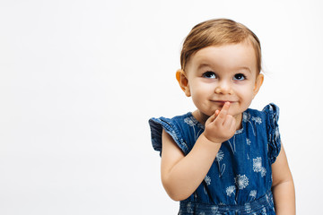 Make a wish - Small child with finger on mouth looking up, isolated on white background
