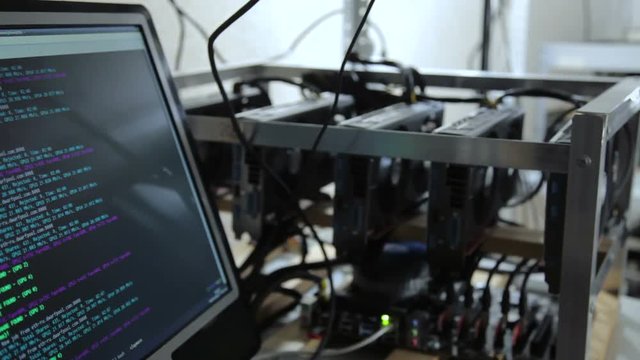 Crop shot in close-up of miner showing smartphone with cryptocurrency rate.