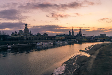 Dresden, Germany old town skyline on the Elbe River at sunset in the winter.