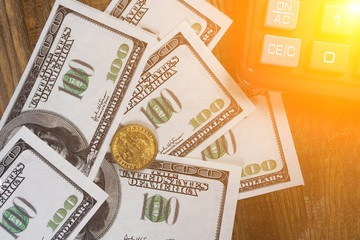 Banknotes, coins calculator on the wood table
