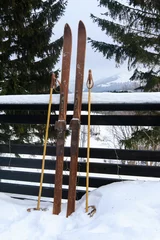 Poster Photo of vintage old wooden skis on the terrace of a country house © lisovoy