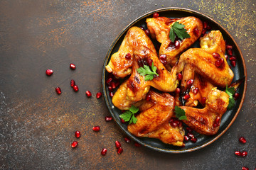 Grilled chicken wings in a honey orange glaze with pomegranate seeds.Top view with copy space.