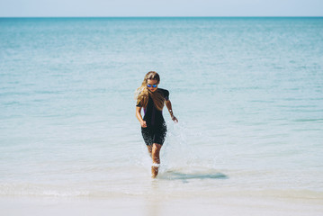 Beautiful woman in wetsuit on the idyllic beach