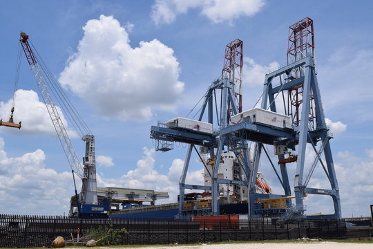 Cargo shipping port  structures and cranes, sunny day.