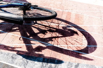 Hinterrad eines Fahrrads und dessen Schatten auf Pflastersteinen