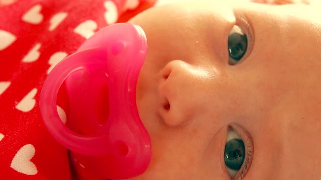 Portrait of a newborn baby girl with pacifier