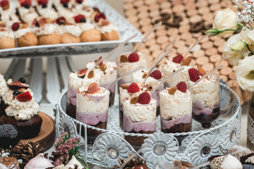 Candybar in a restaurant. Decorated white table fool of sweet pastry