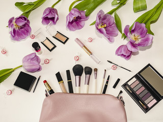 Obraz na płótnie Canvas handbag with cosmetics and flowers