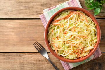 Fresh coleslow salad in bowl on rustic wooden table