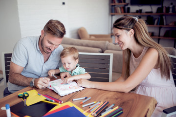 Young parents with young child draw.