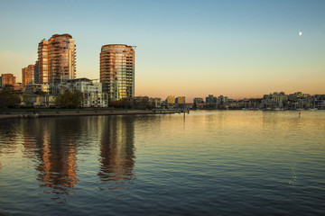 Fototapeta na wymiar Downtown condos reflecting in the calm waters of False Creek during the golden hour