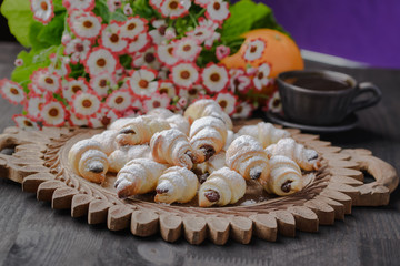 mini croissants on a wooden table,Bagels with a cup of coffee on a wooden table,bagels on a wooden table.