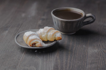 mini croissants on a wooden table,Bagels with a cup of coffee on a wooden table,bagels on a wooden table.