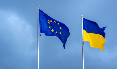 The flag of the European Union and Ukraine, against the background of the sunny sky.