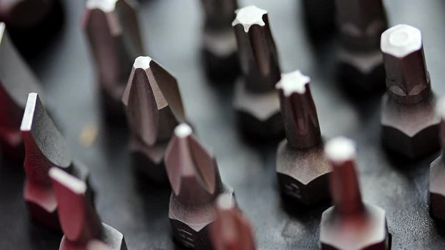 Set of bits for the screws with focus change. Selection of different shapes and bits for a screwdriver. Macro view of tools.