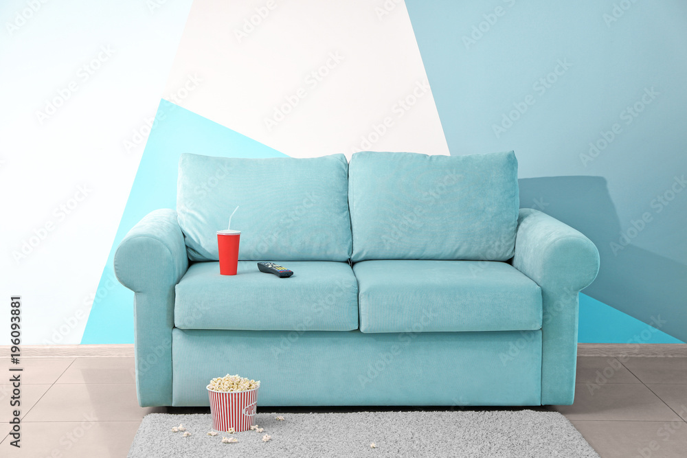 Poster Comfortable couch with popcorn and drink indoors. Home cinema