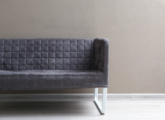 Comfortable sofa near light wall