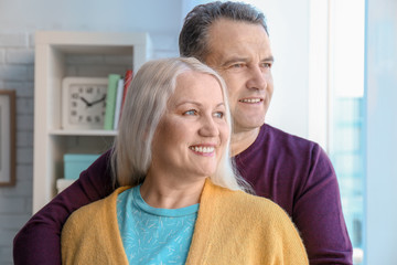 Portrait of happy pensioners at home