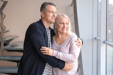 Portrait of happy pensioners at home