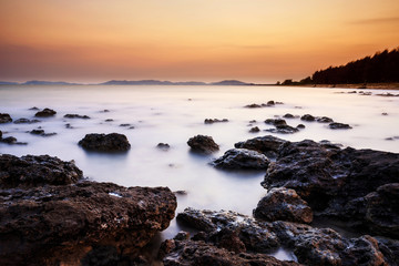 long exposure shooting of small island boat and rock in smoky and soft sea water with blue sky, Sky burst, blurred motion