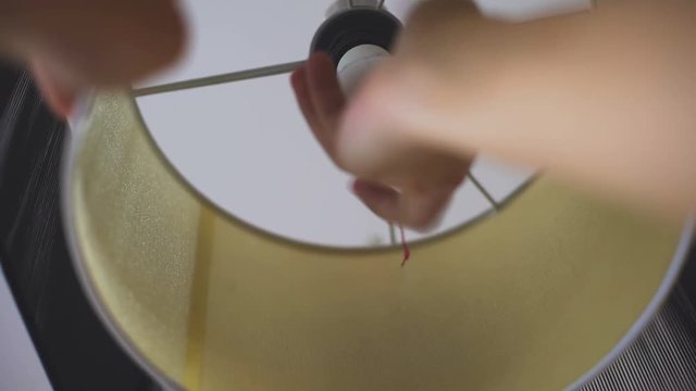 Man putting in lamp energy saving light bulb, rational electricity consumption