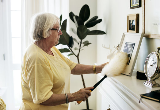 Senior woman dusting a family photo