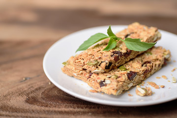 Snack bar or energy bar on white dish and wooden background