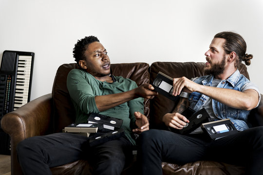 African American male and a Caucasian male hipsters fighting over VHS video tape