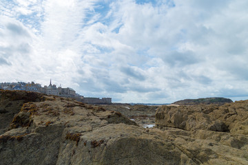 Fototapeta na wymiar Sea rocks with Saint Malo Brittany, Europe on the background