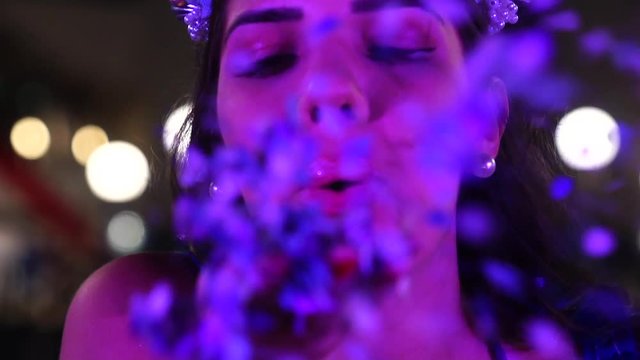 Girl blowing colorful confetti